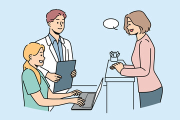 Woman client of clinic stands near reception desk and consults with doctor or chooses convenient time for next appointment. Employees of cosmetology clinic and potential patient are in lobby