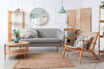 Interior of light living room with sofa, armchair and houseplants