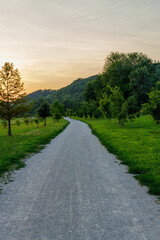 Fototapeta na wymiar gravel path with hills in the background at sunset