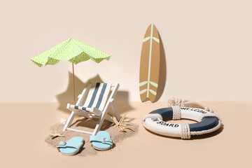 Creative summer composition with mini umbrella, deckchair and beach accessories on color background
