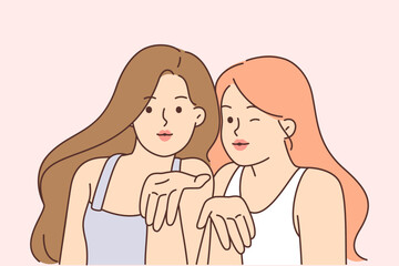 Two seductive women blow kiss and look at screen wanting to flirt or invite guys for walk