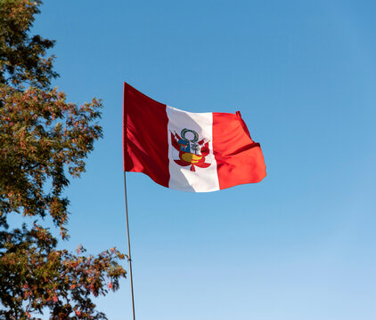 Peruvian flag with the sky behind and trees, national holidays