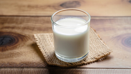 Kefir, buttermilk or yogurt in glass on wooden desk