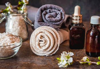 Obraz na płótnie Canvas Beauty spa treatment and relax concept. Towel, sea salt and essential oils on a dark background