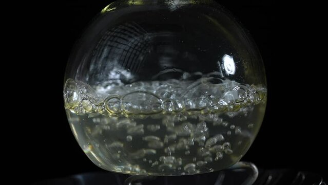 Liquid boils in a laboratory flask. Do drugs in the lab. Slow motion
