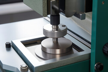 a close-up of the specimen holder on an impact testing device holding a tensioned metal sample