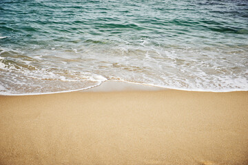 Fototapeta na wymiar Gentle waves on a sandy beach