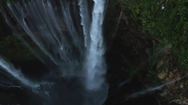 Aerial tilt shot following the Tumpak Sewu waterfall, in East Java, Indonesia