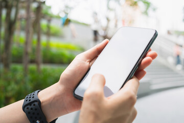 Hand using smartphone in public areas, During leisure time. The concept of using the phone is essential in everyday life.