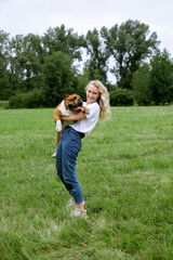 Fototapeta premium young woman playing with English Bulldog at park