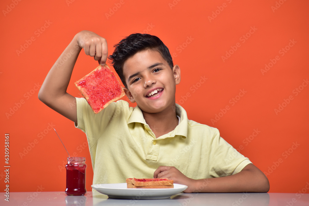 Wall mural kid boy eating bread jam in breakfast