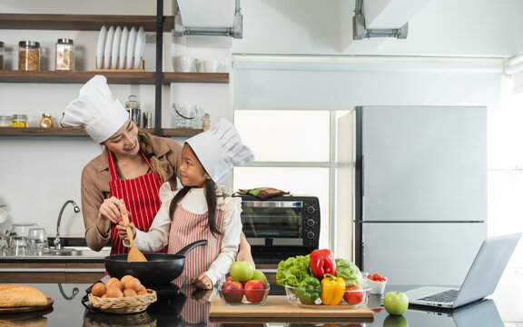 Happy Moment Asian Mother And Daughter Cooking Breakfast Salad In The Kitchen. Mom And Daughter Asian Family Having Fun Preparing Healthy Food Vegetable. Positive Parent And Kid Nice Relationship