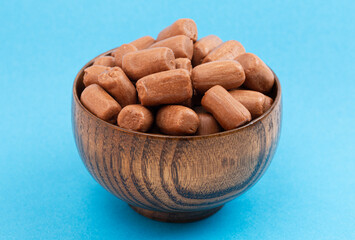 A Pile of Freeze Dried Chocolate Candy Rolls Isolated on a Blue Background