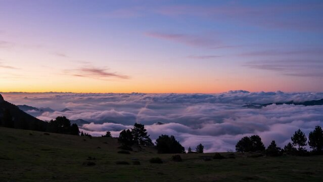 Coll de Pal, Bergueda, Girona, Spain. August 2022. Watch the breathtaking sunrise over the mountains as a sea of clouds ebbs and flows, creating a stunning splash-like effect against the peaks.