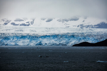 Cruise to Hubbard Glacier Bay in Alaska with floating ice bergs and drift ice floes on ocean water surface surrounded by snow cap mountains and wildlife wild nature scenery Last Frontier adventure © Tamme Wichmann