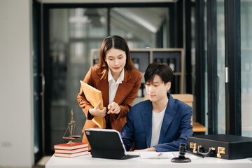 Asian business team and lawyers discussing contract papers sitting at the table. Concepts of law, advice, legal services. at office