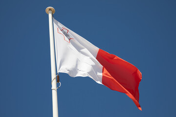 malta maltese flag red white country on top of the mast in the wind and blue sky