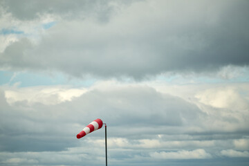 Windsock against sky with heavy clouds