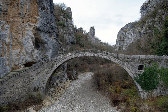 Greece Kokkorou Noutsou arched stone bridge over Voidomatis dry river Zagorohoria Epirus.