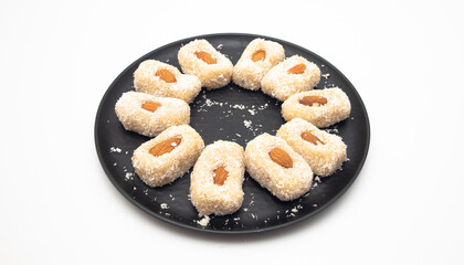 Homemade Indian Coconut Sweets on black plate, white background