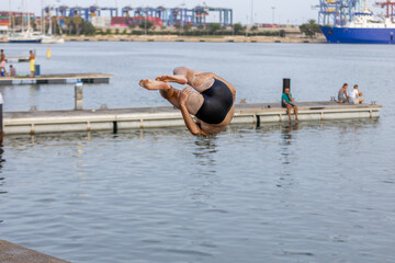 Acr&oacute;bata haciendo exhibici&oacute;n de saltos en el puerto de Valencia 