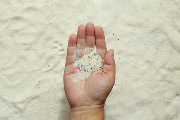 Close-up Microplastic found on beaches lay on people's hands. Microplastics are contaminated in the...