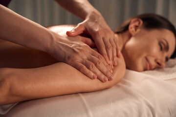 Fototapeta na wymiar Spa patient sleeping during upper arm massage session