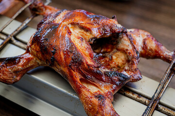 Naklejka premium Huli-huli chicken is a grilled chicken dish in Hawaiian cuisine, prepared by barbecuing a chicken over mesquite wood, Prosopis pallida , kiawe