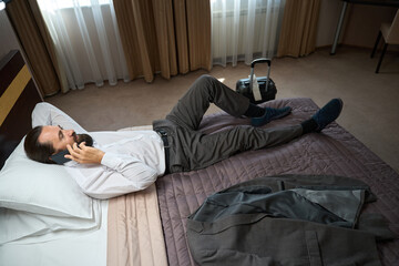 Fototapeta premium Male with the phone lay down to rest from road