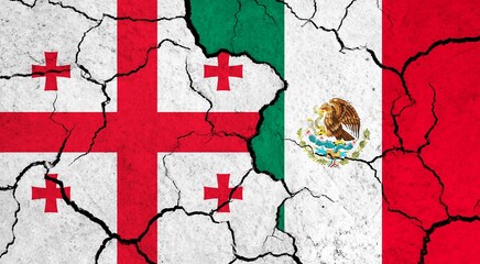 Flags of Georgia and Mexico on cracked surface - politics, relationship concept