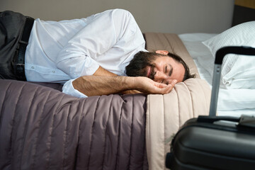 Fototapeta premium Weary traveler lay down to rest on the bed