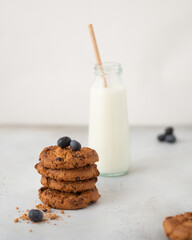 cookies with chocolate chips and
 milk in a bottle on a light background