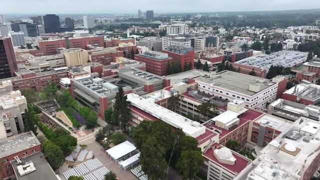 Aerial view flying over UCLA campus blocks rooftops in Los Angeles, California scenic academic cityscape