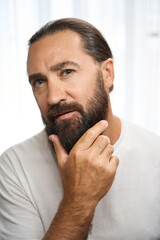 Fototapeta premium Cute male examines his thick beard