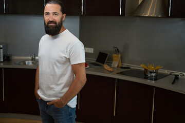 Handsome man stands in the kitchen area of hotel room