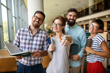 Education campus friendship people concept. Group of happy students studying together in library.