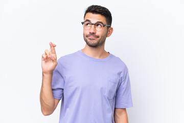 Young caucasian man isolated on white background with fingers crossing and wishing the best