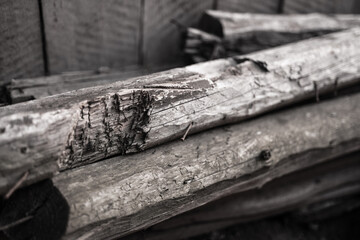 black and white photo of old wooden boards stacked in the backyard