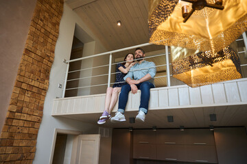 Middle-aged couple sits on the landing on the second floor