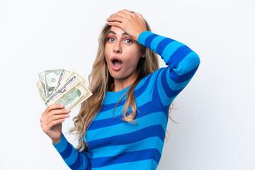 Young Uruguayan woman taking a lot of money isolated on white background doing surprise gesture while looking to the side