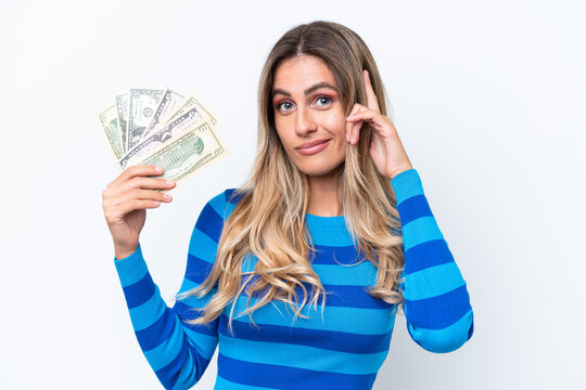 Young Uruguayan woman taking a lot of money isolated on white background thinking an idea