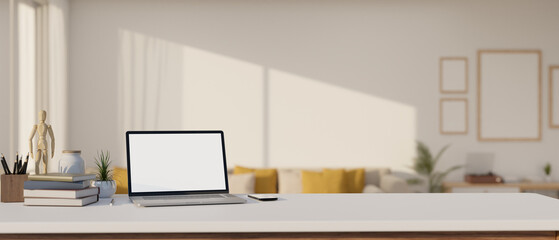 A laptop mockup is on a white tabletop with decor in a modern and cozy living room