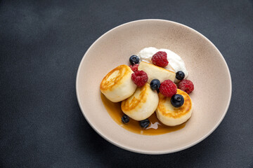 Delicious breakfast. cheesecakes with raspberries and blueberries. Close-up
