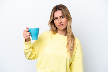 Young Uruguayan woman holding cup of coffee isolated on white background with sad expression