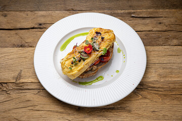 Delicious breakfast. omelette with tomatoes on toast. Close-up