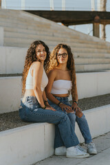 Dos chicas jóvenes juntas sonriendo y disfrutando dandose abrazados y mostrando cariño. Hermanas...