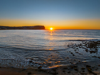Naklejka premium Clear skies and flat surf sunrise seascape