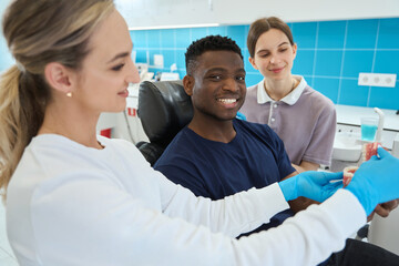Woman dental technician showing 3d jaw model, aesthetic dentistry