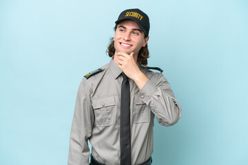 Young safeguard man isolated on blue background looking to the side