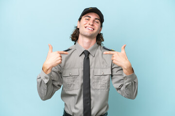 Young safeguard man isolated on blue background proud and self-satisfied